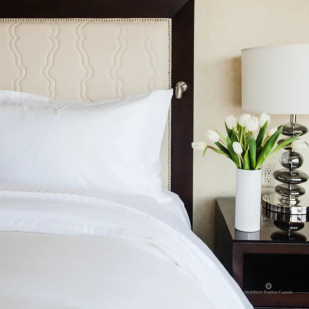 Northern Feather Pillow in a hotel with flowers on the nightstand