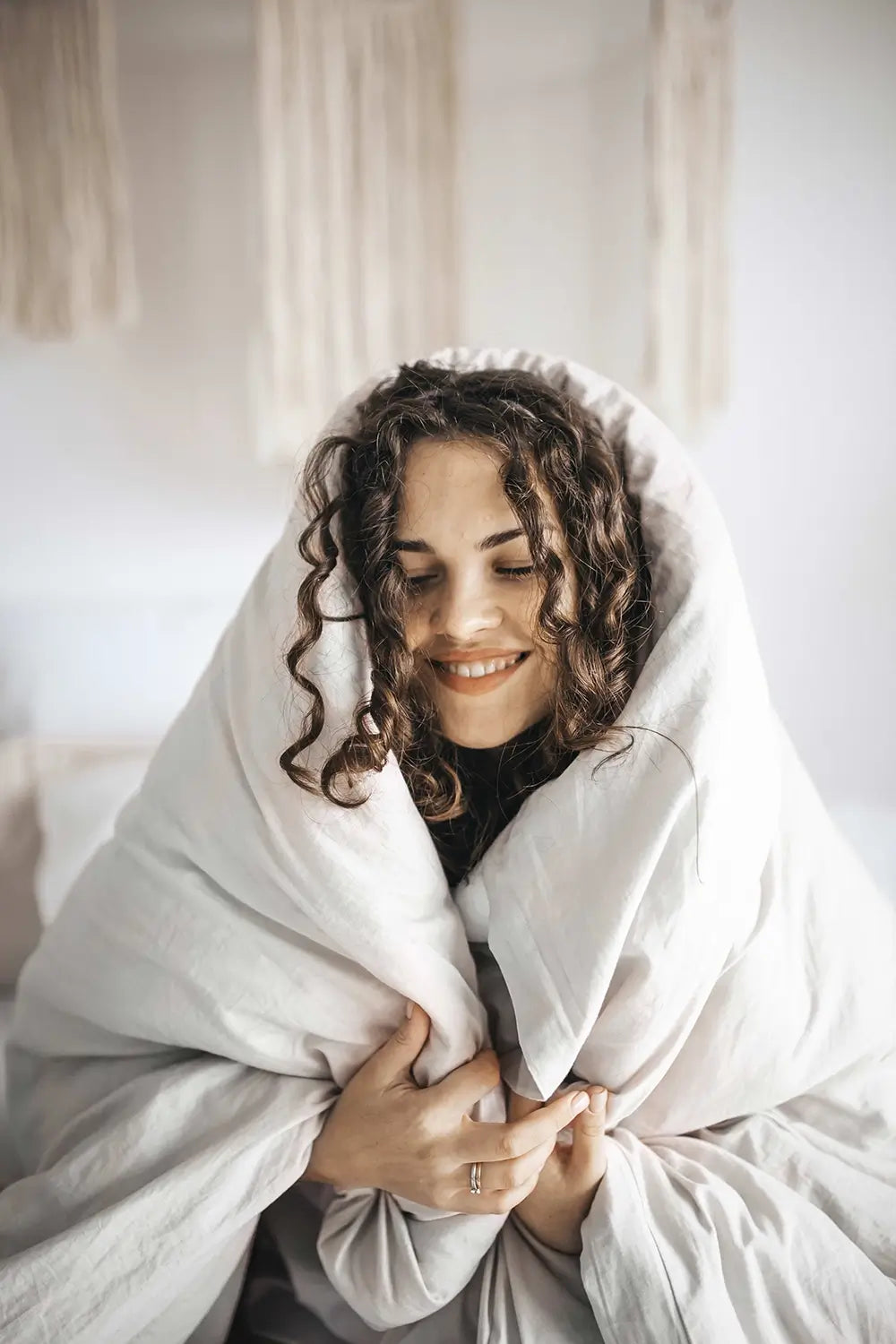 Woman smiling while wrapped in a duvet - Northern Feather Canada eStore